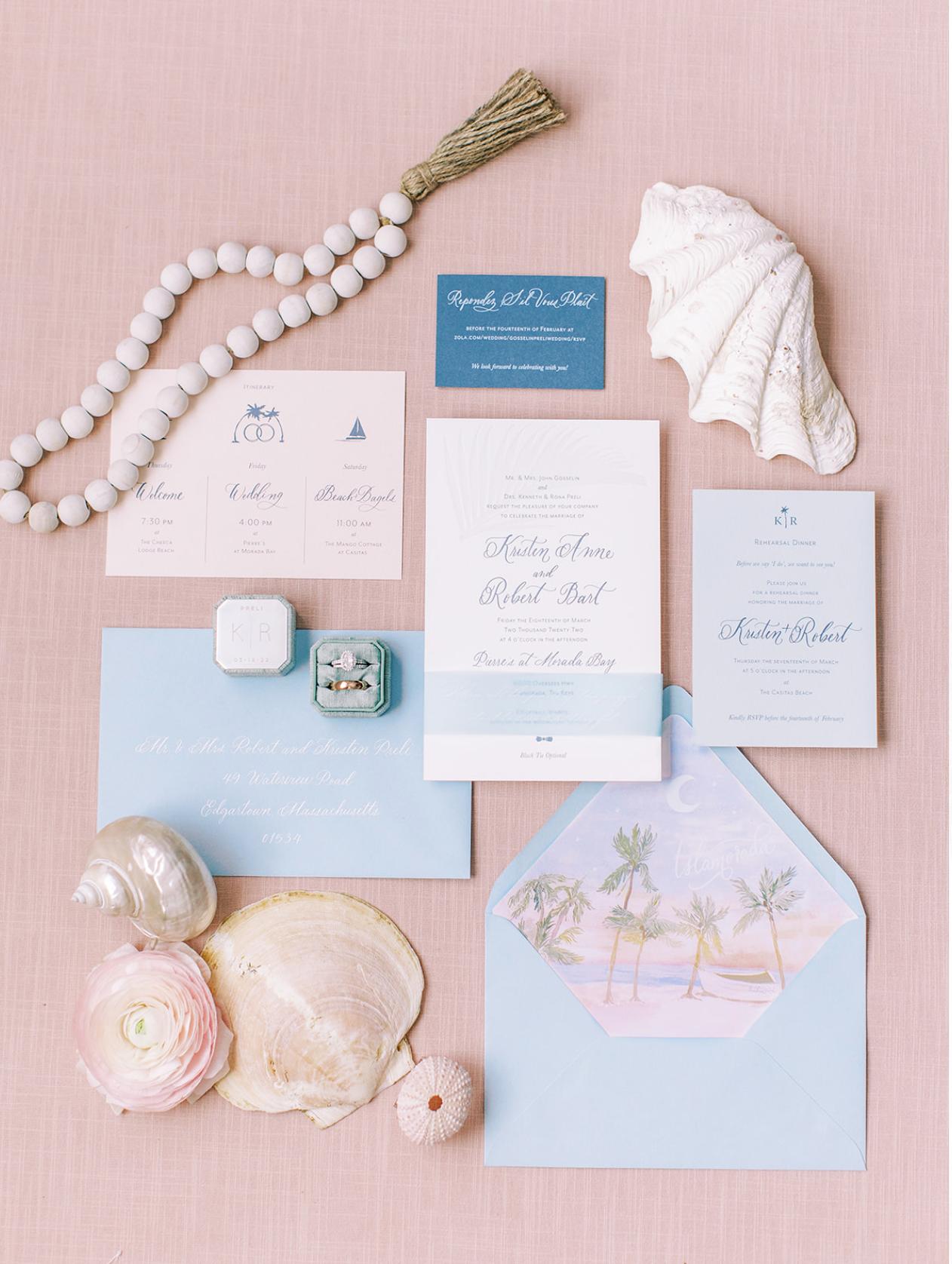 Florida Keys Island destination wedding invitations on pink background flat lay with shells surrounding the stationary.