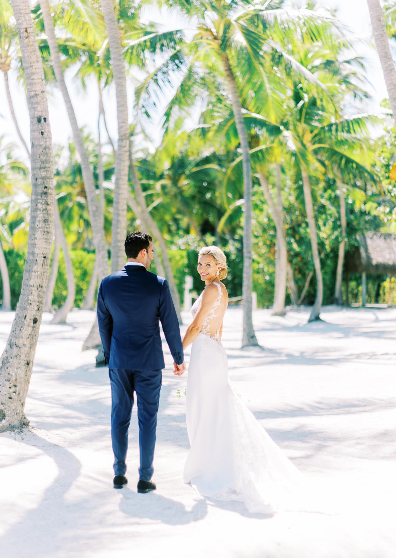 couple standing on beach in Florida Keys Wedding attire with palm trees in the background